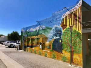 Beautiful mural of train and orange trees on side of building representing Historic Old Town La Verne